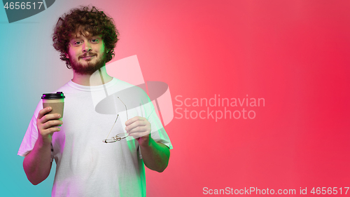 Image of Caucasian young man\'s portrait on gradient studio background in neon