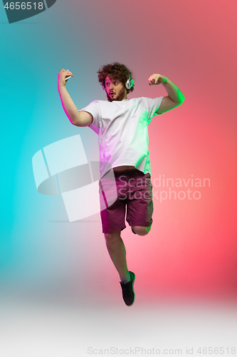 Image of Caucasian young man\'s portrait on gradient studio background in neon