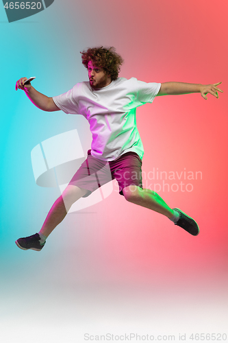 Image of Caucasian young man\'s portrait on gradient studio background in neon