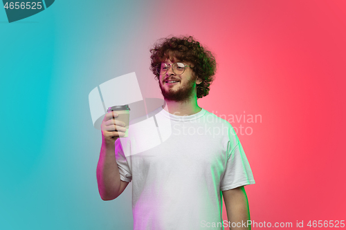 Image of Caucasian young man\'s portrait on gradient studio background in neon