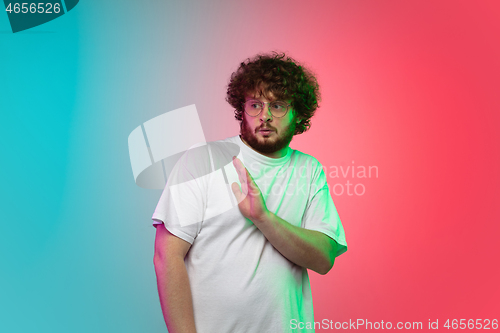 Image of Caucasian young man\'s portrait on gradient studio background in neon