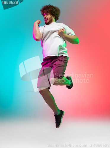 Image of Caucasian young man\'s portrait on gradient studio background in neon