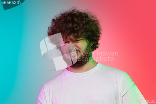 Image of Caucasian young man\'s portrait on gradient studio background in neon