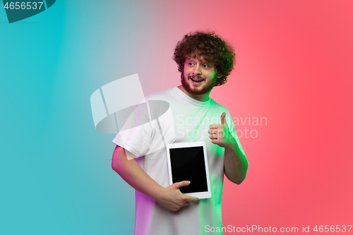 Image of Caucasian young man\'s portrait on gradient studio background in neon