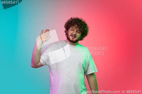 Image of Caucasian young man\'s portrait on gradient studio background in neon