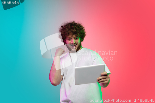 Image of Caucasian young man\'s portrait on gradient studio background in neon