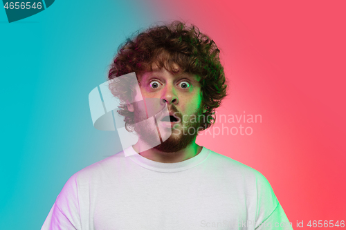 Image of Caucasian young man\'s portrait on gradient studio background in neon