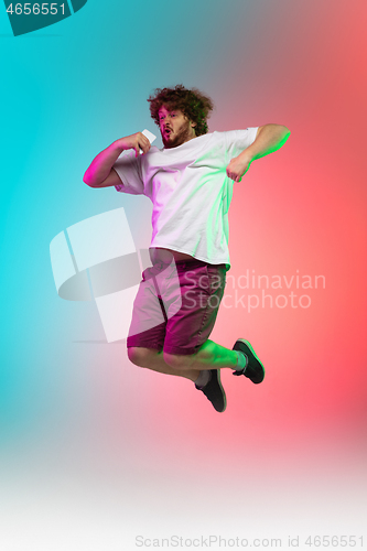 Image of Caucasian young man\'s portrait on gradient studio background in neon