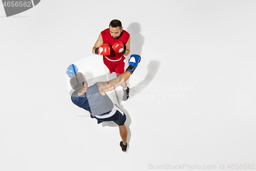 Image of Two professional boxers boxing isolated on white studio background, action, top view