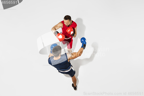 Image of Two professional boxers boxing isolated on white studio background, action, top view