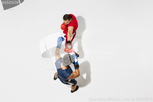 Image of Two professional boxers boxing isolated on white studio background, action, top view