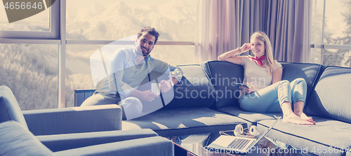 Image of couple relaxing at  home using tablet computer