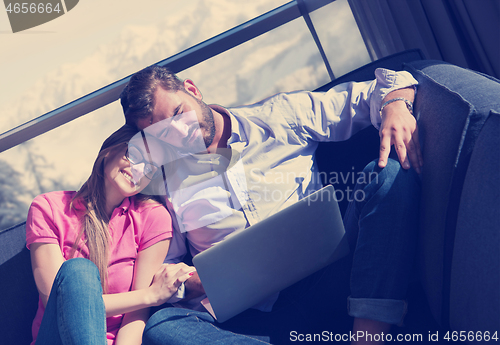 Image of couple relaxing at  home using laptop computers