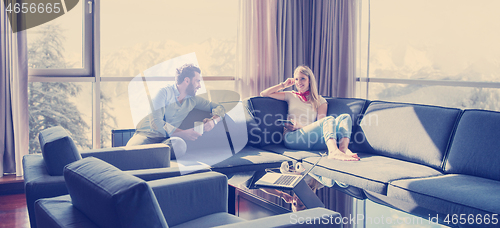 Image of couple relaxing at  home using tablet computer