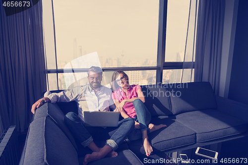 Image of couple relaxing at  home using laptop computers