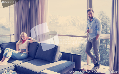 Image of couple relaxing at  home using tablet computer