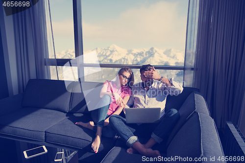 Image of couple relaxing at  home using laptop computers