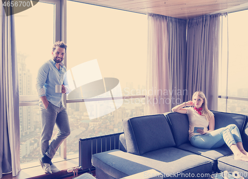 Image of couple relaxing at  home using tablet computer