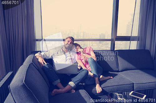 Image of couple relaxing at  home using laptop computers