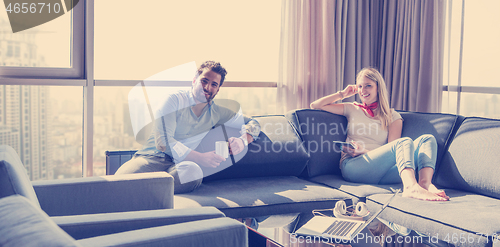 Image of couple relaxing at  home using tablet computer