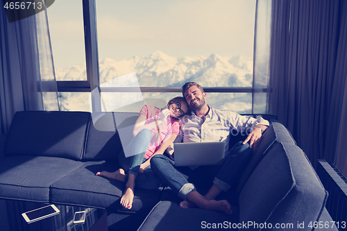 Image of couple relaxing at  home using laptop computers