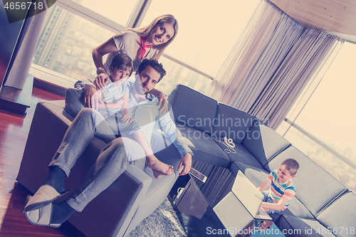 Image of happy young couple spending time with kids