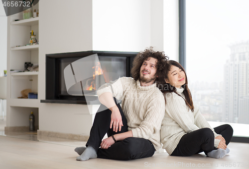 Image of happy multiethnic couple  in front of fireplace