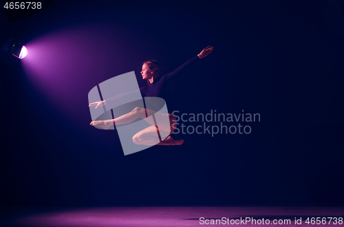 Image of Young female ballet dancer on neon lights studio background.