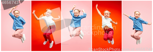 Image of Young happy caucasian teen girl jumping in the air, isolated on pink studio background.