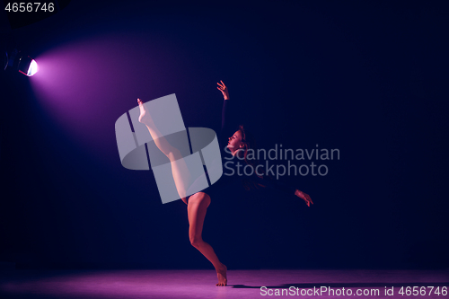 Image of Young female ballet dancer on neon lights studio background.