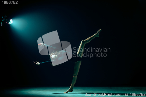 Image of Young female ballet dancer on neon lights studio background.