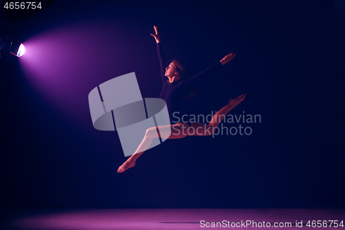 Image of Young female ballet dancer on neon lights studio background.