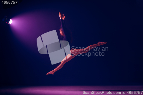 Image of Young female ballet dancer on neon lights studio background.