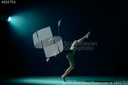 Image of Young female ballet dancer on neon lights studio background.