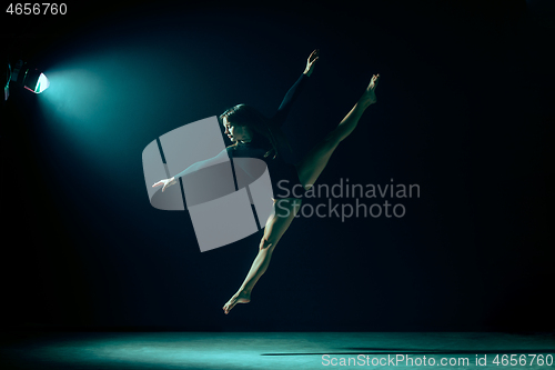 Image of Young female ballet dancer on neon lights studio background.