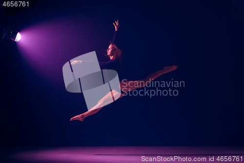 Image of Young female ballet dancer on neon lights studio background.