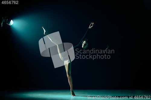 Image of Young female ballet dancer on neon lights studio background.