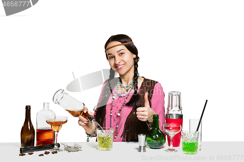 Image of Expert female barman is making cocktail at studio