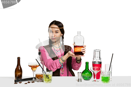 Image of Expert female barman is making cocktail at studio