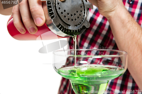 Image of Expert barman is making cocktail at studio