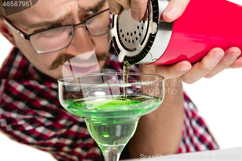 Image of Expert barman is making cocktail at studio