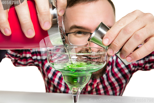 Image of Expert barman is making cocktail at studio