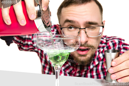 Image of Expert barman is making cocktail at studio