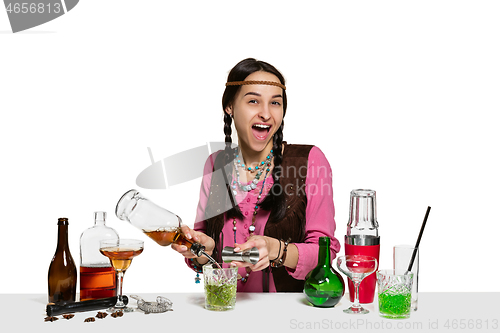 Image of Expert female barman is making cocktail at studio