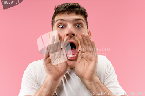 Image of Isolated on pink young casual man shouting at studio