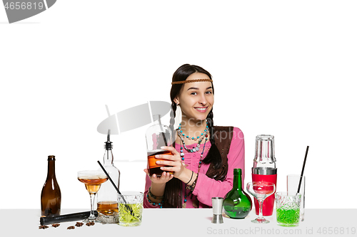 Image of Expert female barman is making cocktail at studio