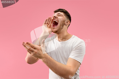 Image of Isolated on pink young casual man shouting at studio