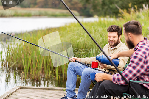 Image of friends fishing and drinking tea from thermos