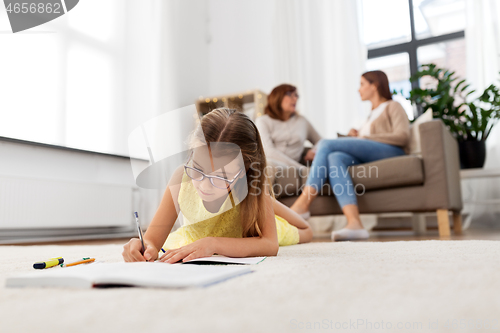 Image of student girl writing to notebook at home