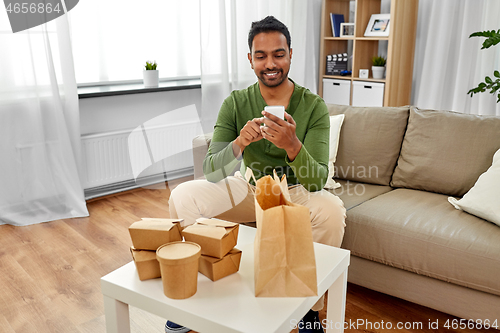 Image of indian man checking takeaway food order at home